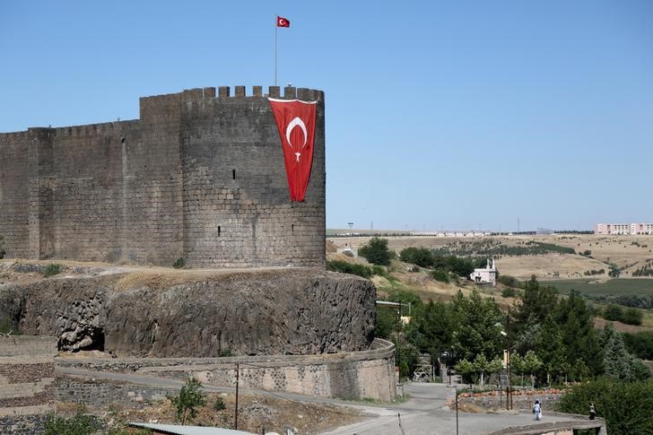 © Reuters. A Turkish flag hangs on the historical city walls at one of the entrance of Sur district in Diyarbakir