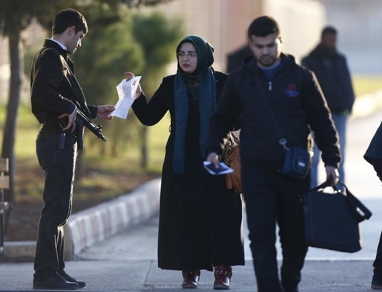 © Reuters. A Syrian woman shows a document while entering at Turkey's Oncupinar border crossing on the Turkish-Syrian border in the southeastern city of Kilis, Turkey