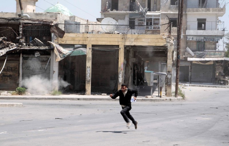 © Reuters. Homem correndo durante troca de tiros na cidade síria de Aleppo