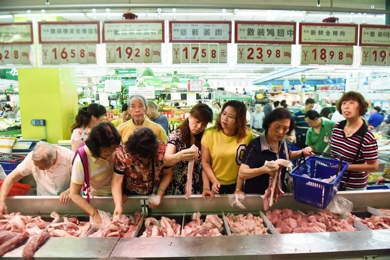 © Reuters. Customers select meat at a supermarket in Hangzhou