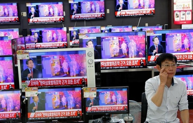 © Reuters. A sales assistant sits next to TV sets broadcasting a news report on North Korea's fifth nuclear test, in Seoul