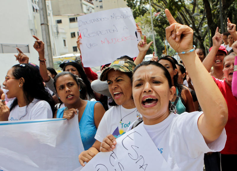 © Reuters. Supporters of Venezuelan President Nicolas Maduro shout slogans as Henry Ramos Allup, President of the National Assembly and deputy of the Venezuelan coalition of opposition parties, speaks to the media in Caracas