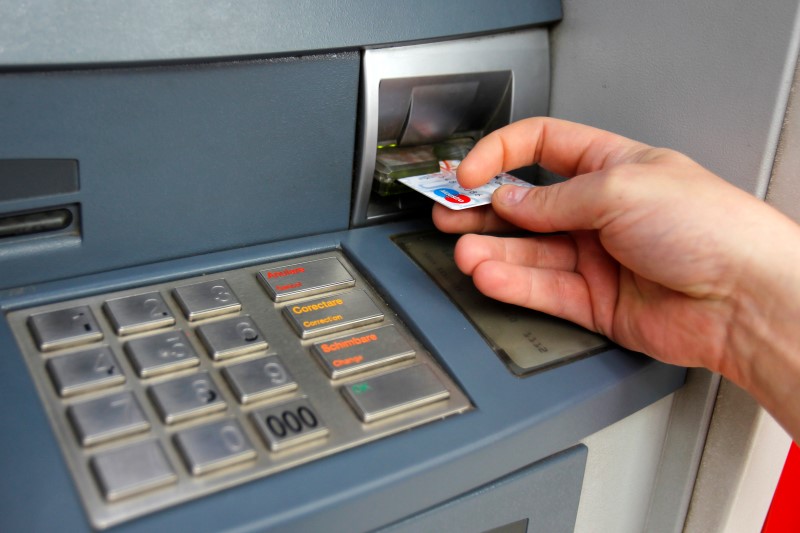 © Reuters. Man uses traditional ATM in Bucharest