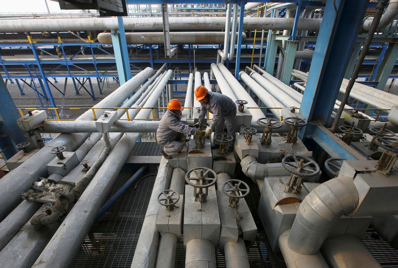 © Reuters. Employees close a valve of a pipe at a PetroChina refinery in Lanzhou, Gansu province