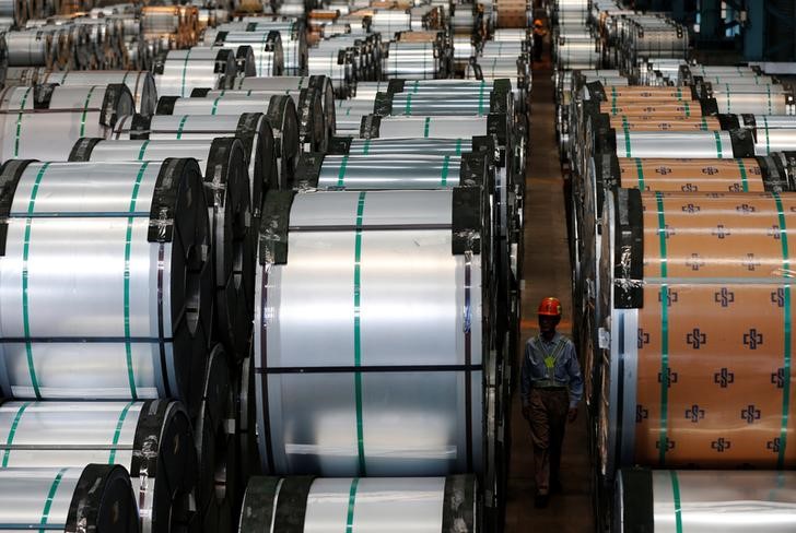 © Reuters. A worker walks past rolls of steel inside the China Steel Corporation factory in Kaohsiung