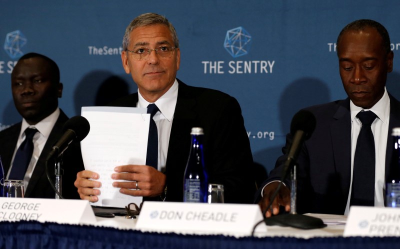 © Reuters. Clooney, with  Cheadle and Adeba, discuss The Sentry's investigation of the role of national corruption in the ongoing humanitarian crisis in South Sudan during a news conference at the National Press Club in Washington, U.S.