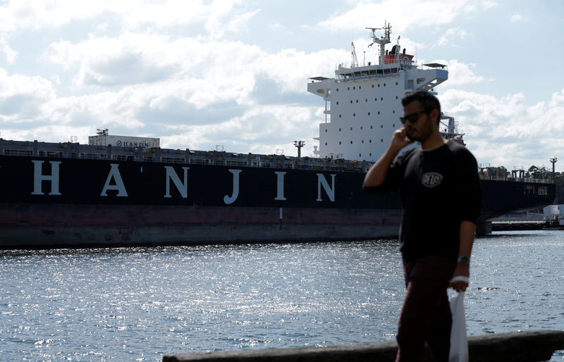 © Reuters. A pedestrian walks past the container ship 'Hanjin California' moored to a dock in Sydney Harbour