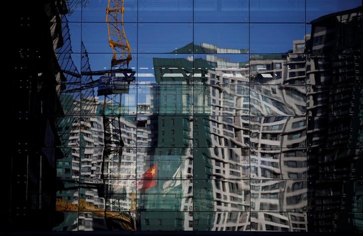 © Reuters. Uma obra e um prédio residencial refletidos em parede espelhada de edifício em Pequim