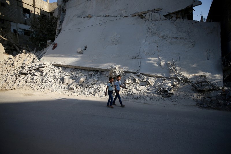 © Reuters. Meninos vistos em meio a destroços em Damasco