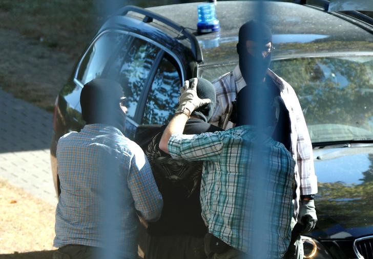 © Reuters. Policiais alemães conduzindo homem suspeito de ter sido enviado pelo Estado Islâmico para a Alemanha