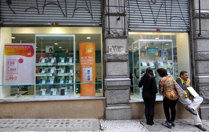 © Reuters. Consumers stand in front of an Oi store, Brazil's largest fixed-line telecoms group, in Sao Paulo