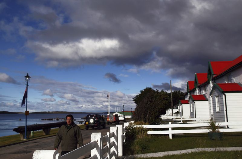 © Reuters. A man walks on Ross road in Stanley