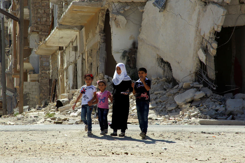 © Reuters. Crianças vistas em meio a destroços na província síria de Idlib