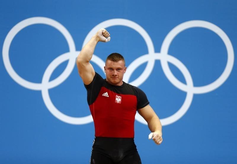 © Reuters. Poland's Tomasz Bernard Zielinski gestures after successful lift on the men's 94Kg group B weightlifting competition at the ExCel venue at the London 2012 Olympic Games