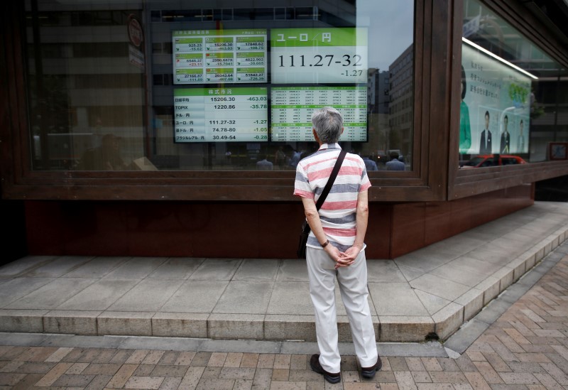 © Reuters. A man looks at an electronic board showing the Japanese yen's exchange rate against Euro outside a brokerage in Tokyo, Japan