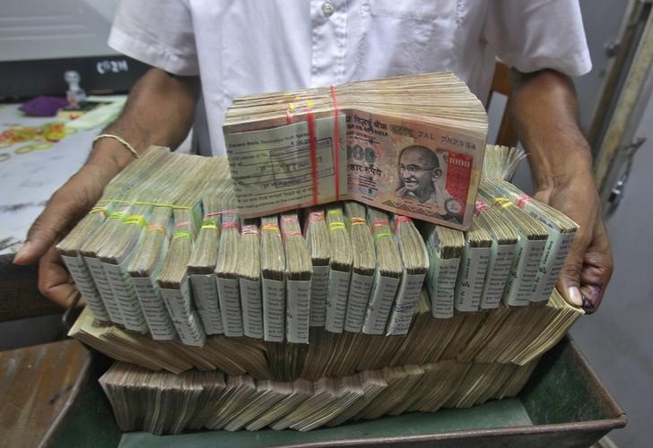 © Reuters. An employee poses with the bundles of Indian rupee notes inside a bank in Agartala