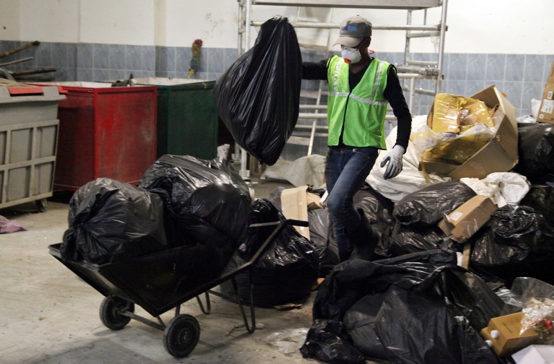 © Reuters. Workers from a environmentally-friendly rubbish disposal business called ScrapApp sort through garbage in a shopping mall in Noida