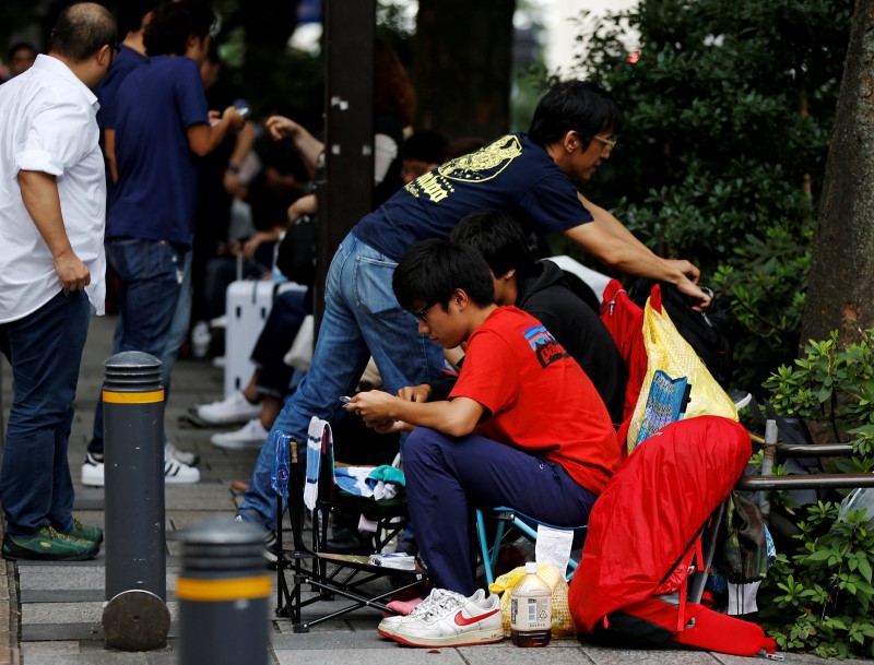 © Reuters. People sit in queue for the release of Apple's new iPhone 7 and 7 Plus in front of the Apple Store in Tokyo's Omotesando shopping district