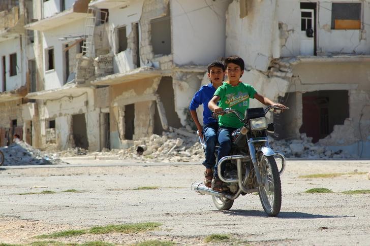 © Reuters. Meninos em moto na cidade síria de Idlib, controlada por rebeldes