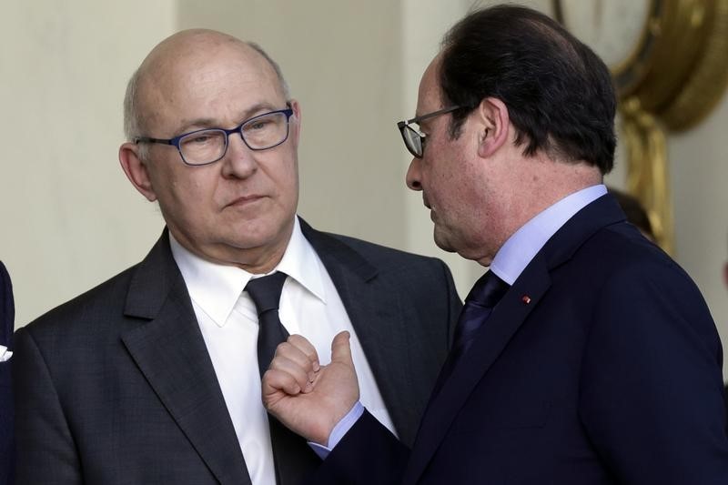© Reuters. French President Hollande speaks with Finance Minister Sapin after a lunch at the Elysee Palace in Paris