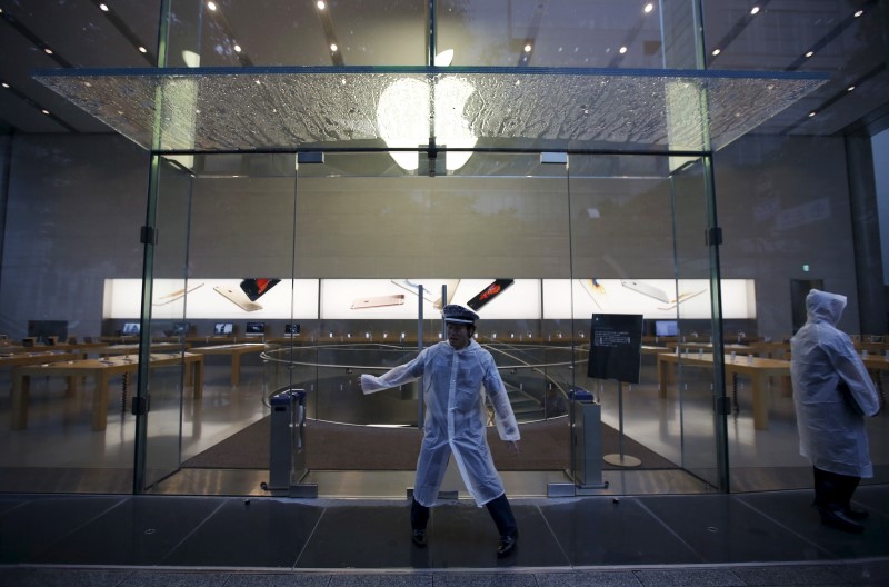 © Reuters. Security officers stand guard before the opening hours of the Apple Store at Tokyo's Omotesando shopping district