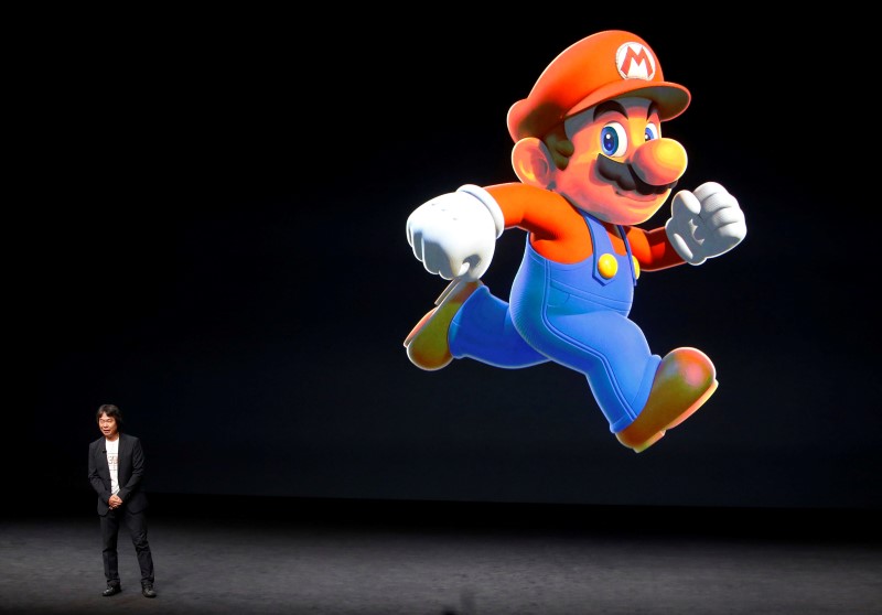 © Reuters. Shigeru Miyamoto stands next to the Super Mario character during an Apple media event in San Francisco