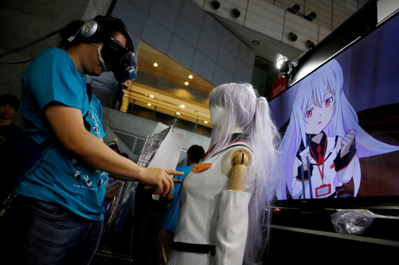 © Reuters. A man touches a mannequin as he tries out a M2 Co.Ltd's "E-mote" system as the monitor shows the image from the VR device at Tokyo Game Show 2016 in Chiba