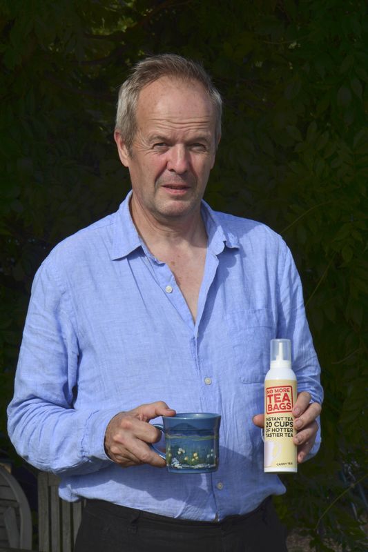 © Reuters. Guy Woodall, the owner of Yum Cha Drinks, poses with a cup of tea and a No More Tea Bags aerosol can, in Leatherhead in Britain