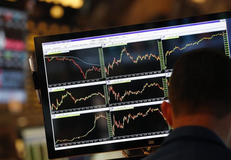 © Reuters. A screen displays stock charts while a trader works at his post on the floor at the New York Stock Exchange