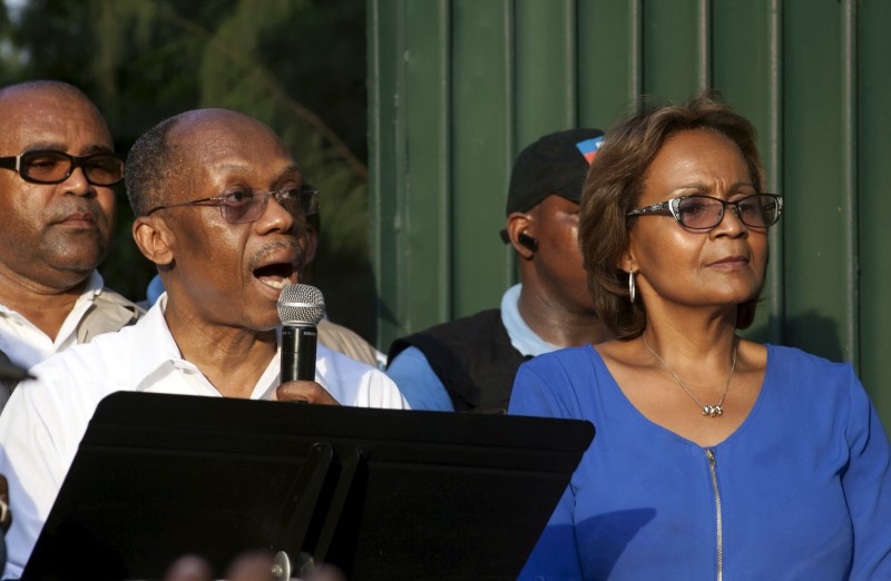 © Reuters. Former Haitian President Jean-Bertrand Aristide addresses the crowd next to presidential candidate Maryse Narcisse of the Lavalas movement during a political rally in Port-au-Prince