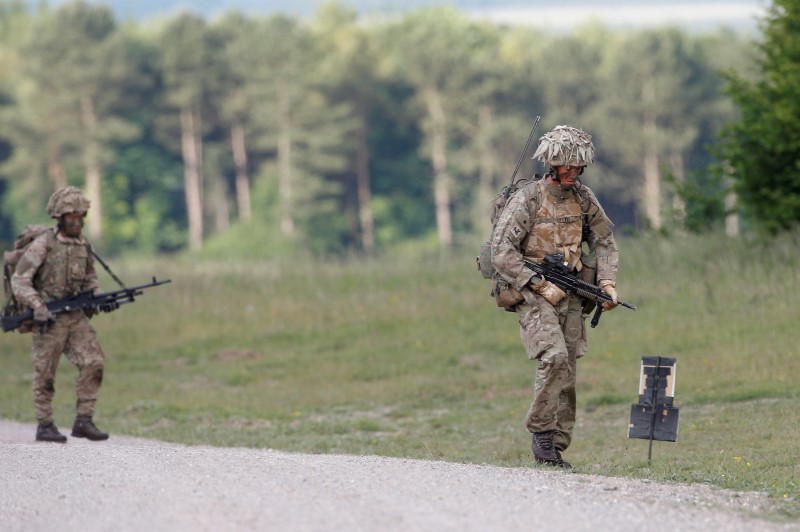 © Reuters. British soldiers on exercise walks across an area of Salisbury Plain, near to Westdown Camp, Britain