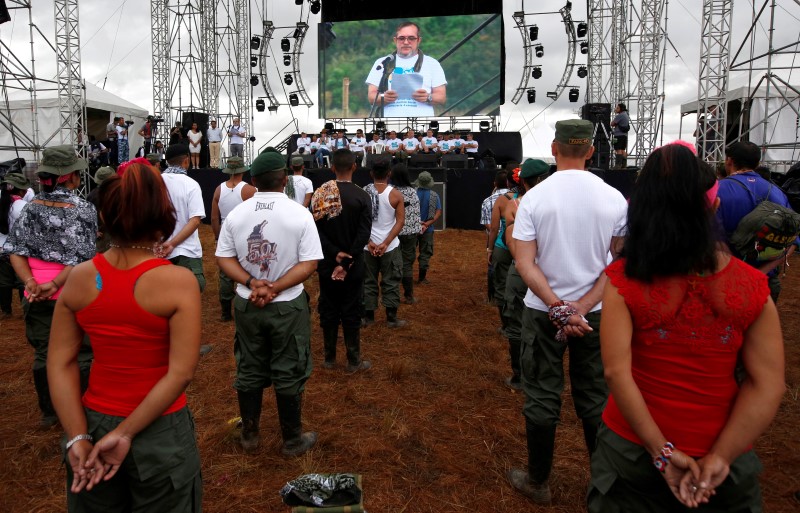 © Reuters. FARC rebel leader Rodrigo Londono, better known by his nom de guerre Timochenko, is seen on a screen during the opening of ceremony congress at the camp where they prepare for ratifying a peace deal with the government, near El Diamante in Yari Plains