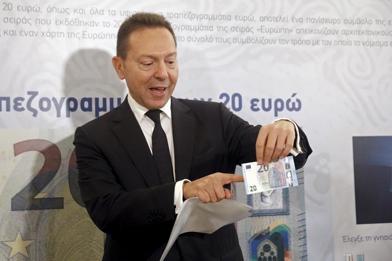 © Reuters. Governor of the Central Bank of Greece Stournaras presents the new 20 Euro banknote at the institution's Museum in Athens