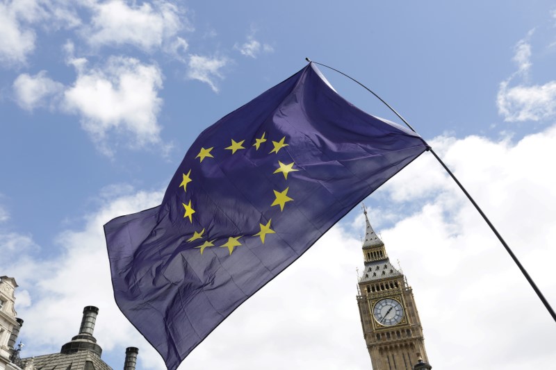 © Reuters. A European Union flag is held in front of the Big Ben clock tower in Parliament Square during a 'March for Europe' demonstration against Britain's decision to leave the European Union, central London