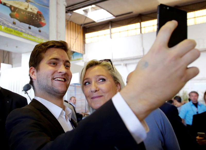 © Reuters. French National Front political party leader Marine Le Pen takes a selfie with a supporter during a FN political rally in Frejus
