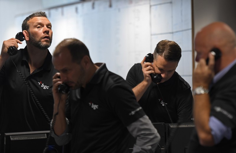 © Reuters. Dealers work on a trading floor at BGC Partners in the Canary Wharf business district in London, Britain