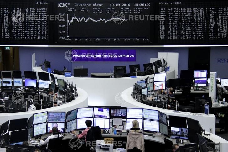 © Reuters. Traders work at their desks in front of the German share price index DAX board in Frankfurt