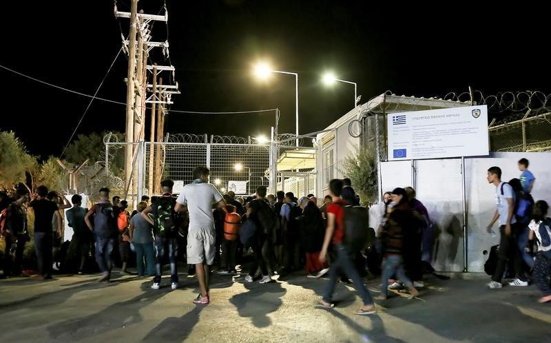 © Reuters. آلاف يفرون من حريق بمخيم لاجئين على جزيرة ليسبوس اليونانية