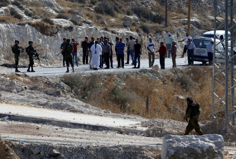 © Reuters. Israeli forces stand guard as they stop Palestinians from passing near the scene where a Palestinian attempted to stab an Israeli soldier at the entrance to the West Bank village of Bani Na'im, near Hebron