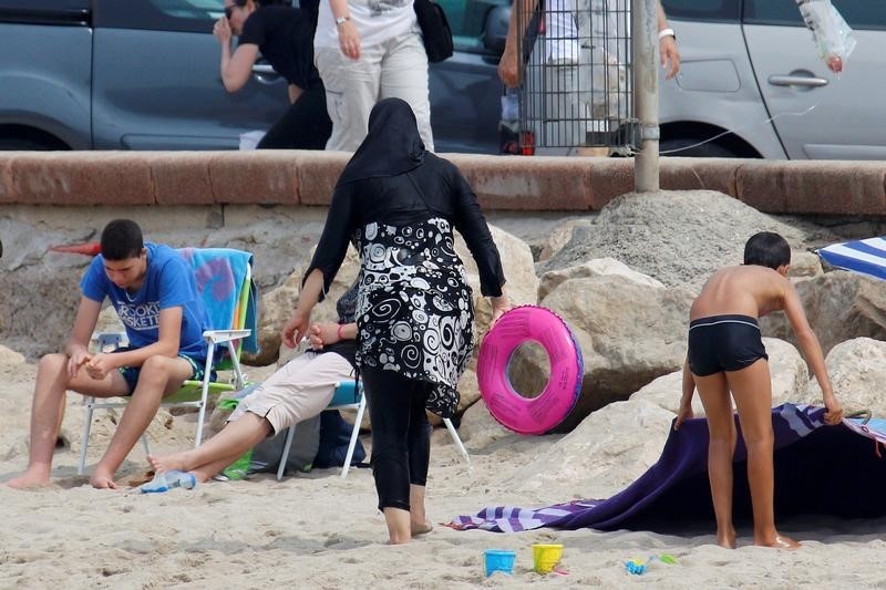 © Reuters. A Muslim woman wears a burkini, a swimsuit that leaves only the face, hands and feet exposed, on a beach in Marseille