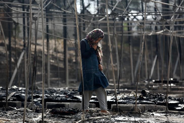 © Reuters. Imigrante em meio a detroços de acampamento que pegou fogo em Lesbos, na Grécia