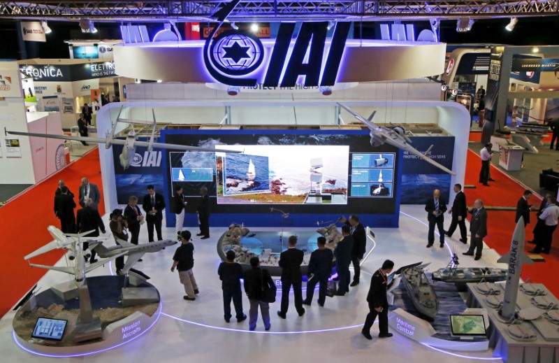 © Reuters. Visitors watch a demonstration at the Israel Aerospace Industries (IAI) booth in the IMDEX Asia maritime defence exhibition in Singapore