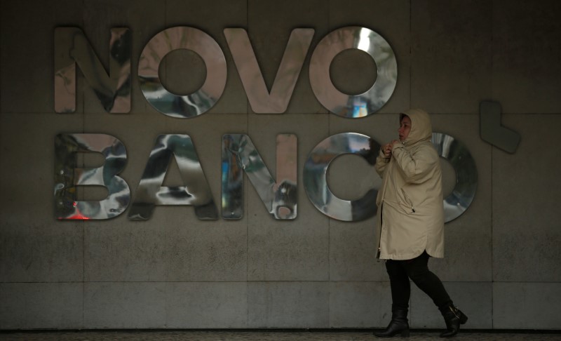 © Reuters. A woman walks near the logo of Portuguese bank Novo Banco in downtown Lisbon