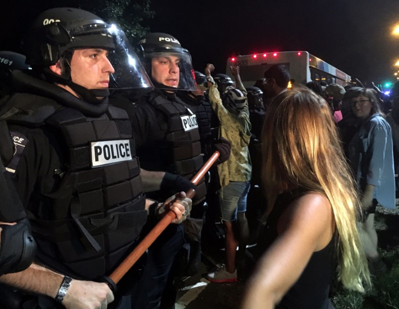 © Reuters. Police officers wearing riot gear block a road during protests after police fatally shot a man in the parking lot of an apartment complex in Charlotte