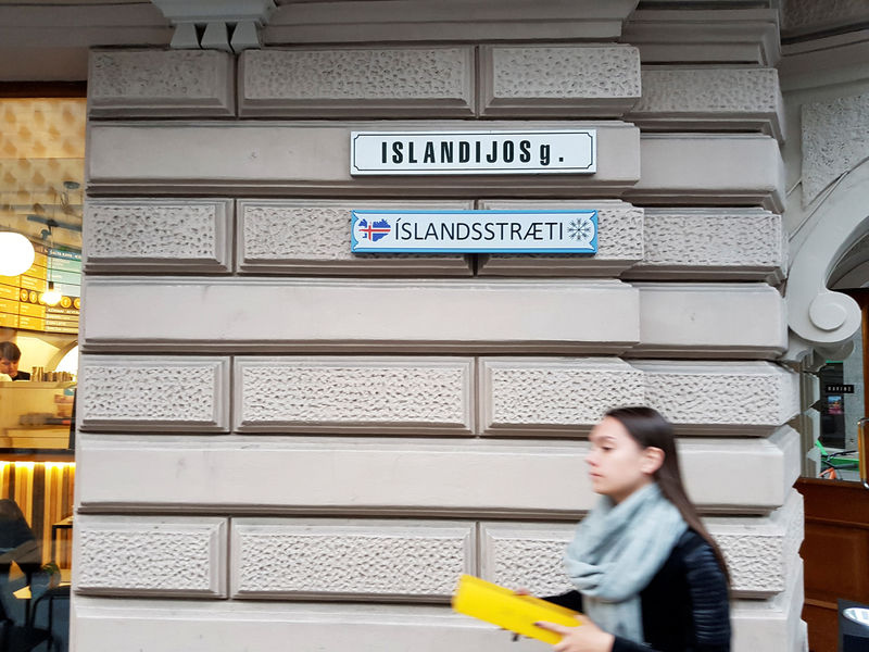 © Reuters. A woman walks past street signs in Lithuanian and Icelandic languages in Vilnius