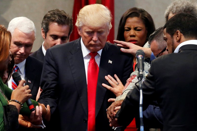 © Reuters. Members of the clergy lay hands and pray over Republican presidential nominee Donald Trump at the New Spirit Revival Center in Cleveland Heights