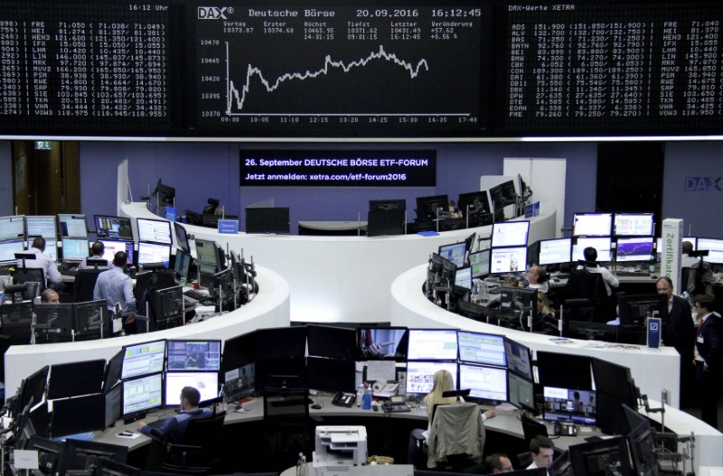 © Reuters. Traders work at their desks in front of the German share price index DAX board in Frankfurt