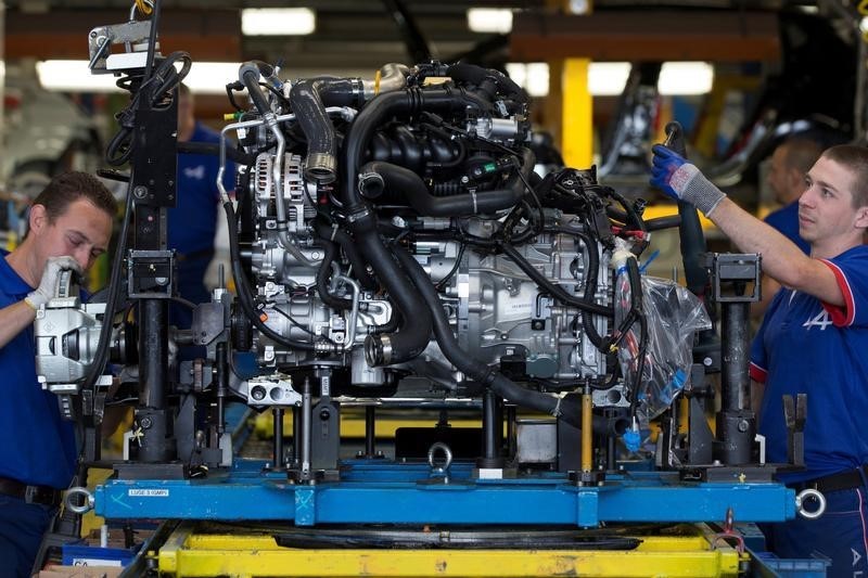 © Reuters. Employees of French carmaker Renault handle a new Clio RS engine on the assembly line at Renault factory in Dieppe