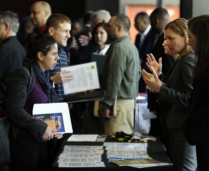 © Reuters. Legal firm Hogan Lovells representative Nina LeClair talks to U.S. military veteran applicants at a hiring fair for veteran job seekers and military spouses at the Verizon Center in Washington