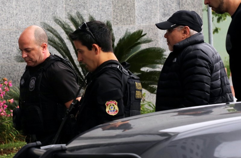 © Reuters. Brazil's former Finance Minister Mantega is escorted by federal police officers as he arrives at the Federal Police headquarters in Sao Paulo